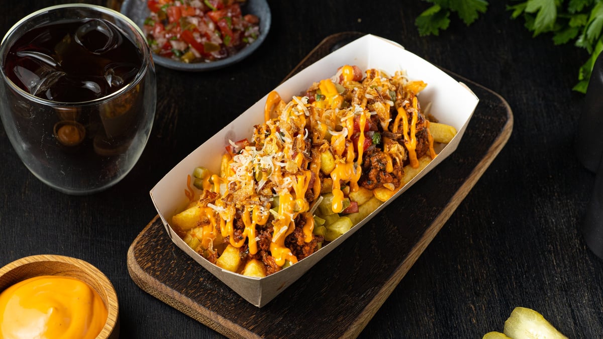 A generous tray of loaded fries topped with seasoned meat, tzatziki and fresh toppings